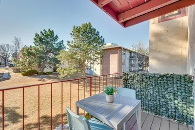 a patio with a table and chairs on a balcony at Cozy Westminster Condo 14 Mi to Downtown Denver! in Westminster