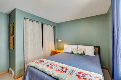 a bedroom with a bed with a blue wall at 13 Mi to Winter Park Mtn-View Granby Cabin in Granby
