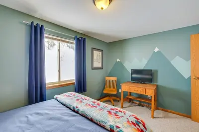 a bedroom with a bed and a desk with a television at 13 Mi to Winter Park Mtn-View Granby Cabin in Granby