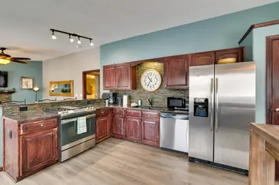 a kitchen with wooden cabinets and stainless steel appliances at 13 Mi to Winter Park Mtn-View Granby Cabin in Granby