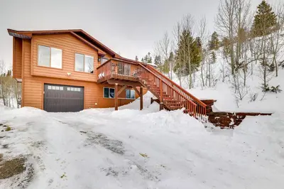 a house with a wooden staircase in the snow at 13 Mi to Winter Park Mtn-View Granby Cabin in Granby