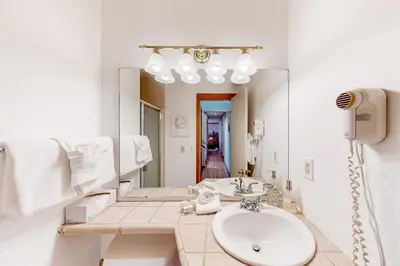 a white bathroom with a sink and a mirror at Lake to Mountain in Keystone