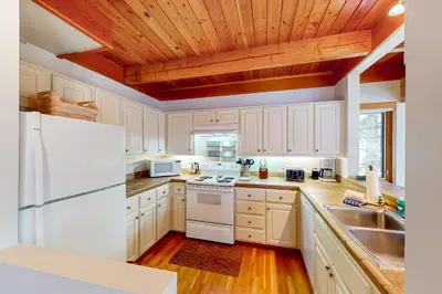 a kitchen with white appliances and a wooden ceiling at Lake to Mountain in Keystone