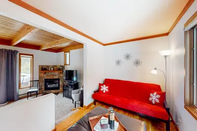 a living room with a red couch and a fireplace at Lake to Mountain in Keystone
