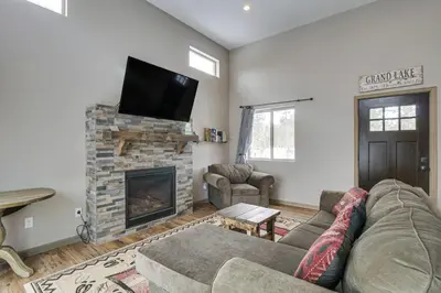 a living room with a couch and a fireplace at Hike and Ski Grand Lake Cabin with Mtn-View Deck in Grand Lake