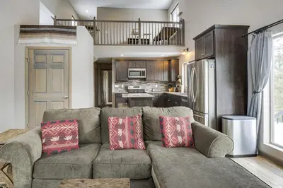 a living room with a couch and a kitchen at Hike and Ski Grand Lake Cabin with Mtn-View Deck in Grand Lake