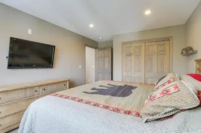 a bedroom with a bed and a flat screen tv at Hike and Ski Grand Lake Cabin with Mtn-View Deck in Grand Lake