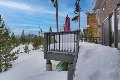 a bench in the snow next to a house at Hike and Ski Grand Lake Cabin with Mtn-View Deck in Grand Lake