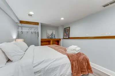 a bedroom with a white bed with towels on a table at 1 Mi to Coors Field Cozy Denver Studio with Patio! in Denver