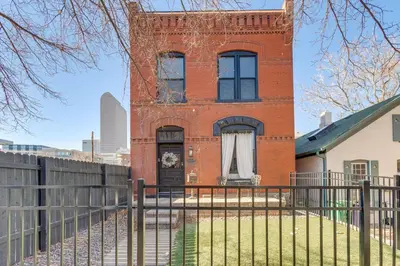a brick house with a fence in front of it at 1 Mi to Coors Field Cozy Denver Studio with Patio! in Denver
