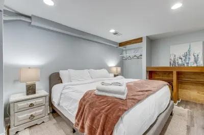 a bedroom with a large white bed and a desk at 1 Mi to Coors Field Cozy Denver Studio with Patio! in Denver