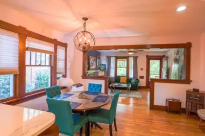 a dining room with a table and green chairs at Charming 1920s Retreat Modern Kitchen 5 minutes to Dining and Med District in Denver