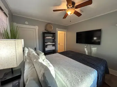a bedroom with a bed and a ceiling fan at Charming 1920s Retreat Modern Kitchen 5 minutes to Dining and Med District in Denver