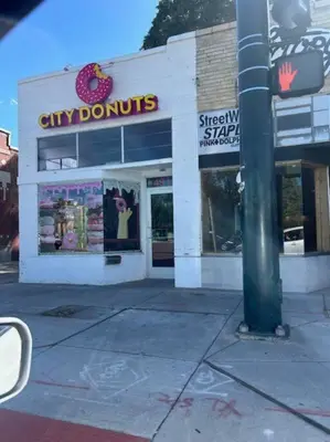 a city donut shop on a city street with a pole at Charming 1920s Retreat Modern Kitchen 5 minutes to Dining and Med District in Denver