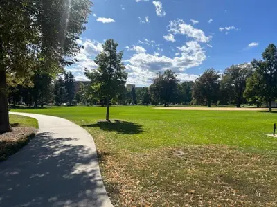 a path in a park with a tree and a field at Charming 1920s Retreat Modern Kitchen 5 minutes to Dining and Med District in Denver