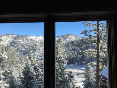 a view of a snowy mountain from a window at Morrison Colorado Mountain Getaway - Red Rocks in Morrison