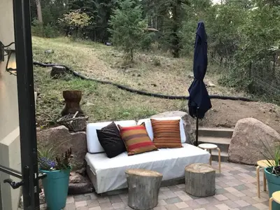 a white couch with colorful pillows on a patio at Morrison Colorado Mountain Getaway - Red Rocks in Morrison