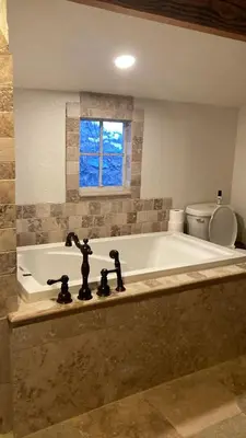 a bathroom with a tub with a window and a toilet at Morrison Colorado Mountain Getaway - Red Rocks in Morrison