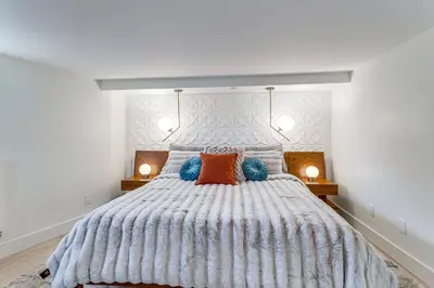 a bedroom with a large bed with blue and orange pillows at 2 Mi to Downtown Denver Stylish Gem with Fireplace! in Denver