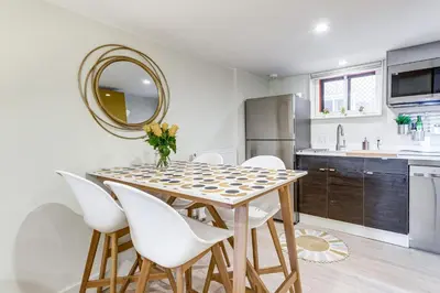 a kitchen with a table with white chairs and a mirror at 2 Mi to Downtown Denver Stylish Gem with Fireplace! in Denver