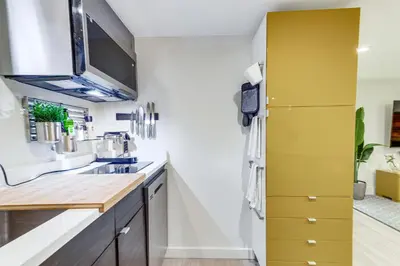 a kitchen with a sink and a yellow cabinet at 2 Mi to Downtown Denver Stylish Gem with Fireplace! in Denver