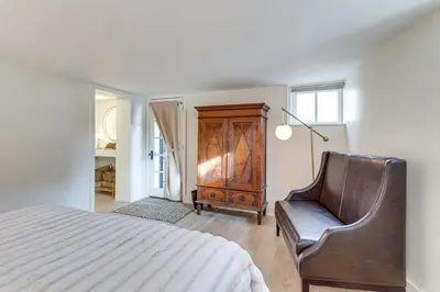 a bedroom with a bed and a chair and a dresser at 2 Mi to Downtown Denver Stylish Gem with Fireplace! in Denver