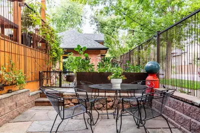 a patio with a table and chairs and a fence at 2 Mi to Downtown Denver Stylish Gem with Fireplace! in Denver