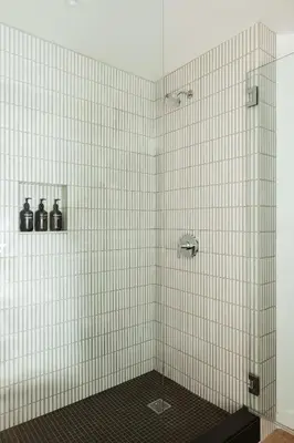 a bathroom with a shower with white tiled walls at Populus in Denver