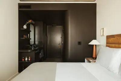 a bedroom with a large white bed and a door at Populus in Denver