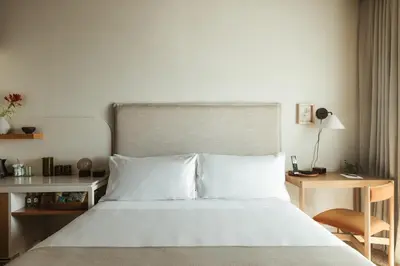 a bedroom with a white bed with a desk and a bed sidx sidx at Populus in Denver