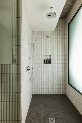 a bathroom with a shower with white tiles at Populus in Denver