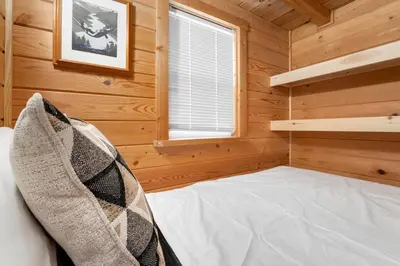 a small bedroom with a bed in a wooden cabin at Riverside Colorado in Bellvue