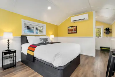 a bedroom with a large bed with yellow walls at Riverside Colorado in Bellvue