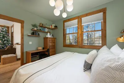 a bedroom with a white bed and a christmas tree at Sundog Condo in Granby Ranch in Granby