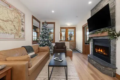 a living room with a fireplace and a christmas tree at Sundog Condo in Granby Ranch in Granby