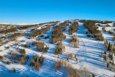 an aerial view of a snow covered hill with trees at Sundog Condo in Granby Ranch in Granby