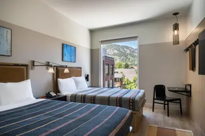a hotel room with two beds and a window at Moxy Boulder University in Boulder