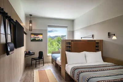 a bedroom with a bed and a window at Moxy Boulder University in Boulder