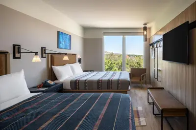 a hotel room with two beds and a large window at Moxy Boulder University in Boulder