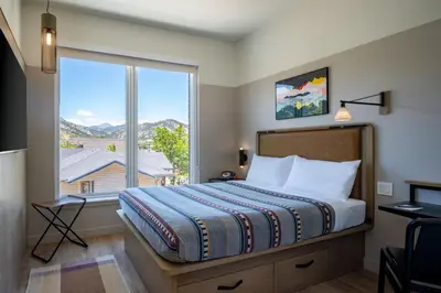 a bedroom with a bed and a large window at Moxy Boulder University in Boulder