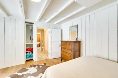 a bedroom with white walls and a bed and a dresser at 3 Mi to Rocky Mtn Natl Park Grand Lake Cabin in Grand Lake