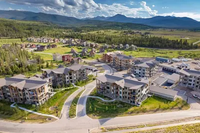 an aerial view of an apartment complex with mountains in the background at NEW Condo Grand Park W/Hot Tub & Mountain View in Fraser
