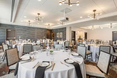 a banquet room with white tables and chairs at Cambria Hotel Denver Downtown RiNo in Denver