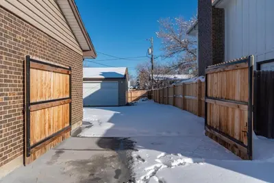a house with wooden gates and a snowy driveway at Downtown Denver: 4bd - Game/Movie Room - Backyard in Arvada