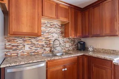 a kitchen with wooden cabinets and a sink at Downtown Denver: 4bd - Game/Movie Room - Backyard in Arvada
