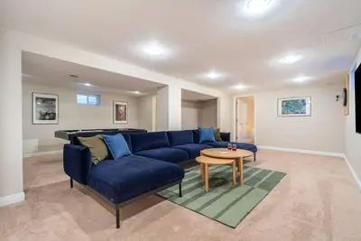 a living room with a blue couch and a table at Downtown Denver: 4bd - Game/Movie Room - Backyard in Arvada