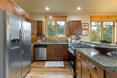 a kitchen with a stainless steel refrigerator and wooden cabinets at 6554 Settlers Creek townhouse in Keystone