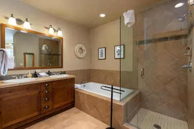 a bathroom with a tub and a glass shower at 6554 Settlers Creek townhouse in Keystone