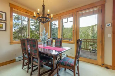 a dining room with a table and chairs and a balcony at 6554 Settlers Creek townhouse in Keystone