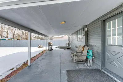 a covered porch of a house with two chairs at Covered Patio, Gas Grill and Yard Sheridan Home! in Sheridan